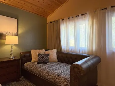 a leather couch in a room with a window at Lily of the Valley - Big Wall, Yosemite Day Use Reservations, Breakfast, Forest View and WiFi in Yosemite West