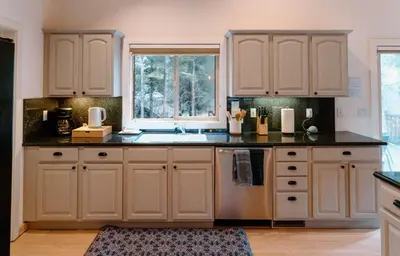 a kitchen with white cabinets and a sink and a window at Beautiful and Spacious Home - Walk to Lake & Beach in Tahoma