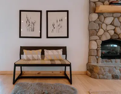 a living room with a bench in front of a fireplace at Beautiful and Spacious Home - Walk to Lake & Beach in Tahoma