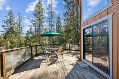 a deck with a table and an umbrella at Golden Peak Cabin home in Groveland