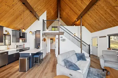 a kitchen and living room with wood ceilings at Golden Peak Cabin home in Groveland