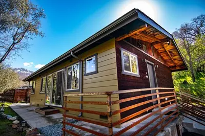 a tiny house in the woods with a porch at Alta Peak Penzion in Three Rivers