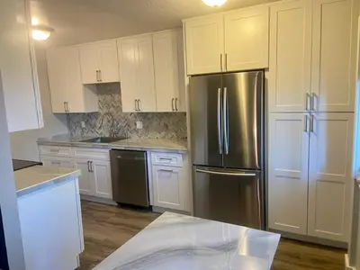 a kitchen with white cabinets and a stainless steel refrigerator at North Tahoe Escape in Incline Village
