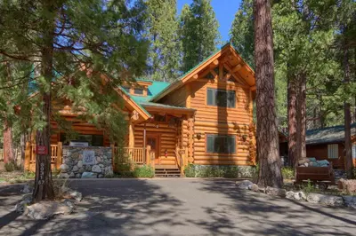 a log cabin in the woods with a driveway at Yosemite's Luxury Estate at The Redwoods in Yosemite 2349 in Wawona