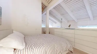 a bedroom with white walls and a bed with a striped blanket at Walk to Canyon Lodge Ski back Modern Space in Mammoth Lakes