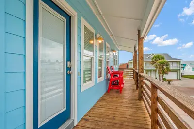 a deck with a red chair on a blue house at Why Knot Relax - Heated PRIVATE Pool Beach Gear Credit Included in Fresno