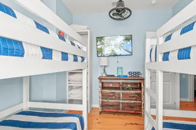 a bedroom with two bunk beds and a dresser at Why Knot Relax - Heated PRIVATE Pool Beach Gear Credit Included in Fresno