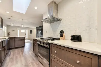 a large kitchen with brown cabinets and a stove at Charming Home, near beautiful park and tennis courts! in Roseville