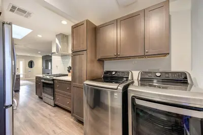 a kitchen with stainless steel appliances and wooden cabinets at Charming Home, near beautiful park and tennis courts! in Roseville