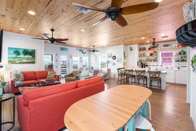 a living room with red chairs and a wooden ceiling at Mermaid Cove PA - Beach Gear Credit Included in Fresno