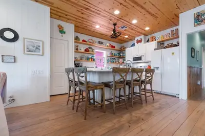 a kitchen with wooden ceilings and a table and chairs at Mermaid Cove PA - Beach Gear Credit Included in Fresno