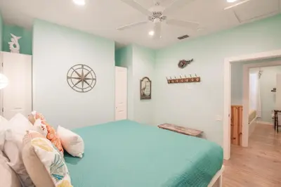 a bedroom with a bed and a ceiling fan at Mermaid Cove PA - Beach Gear Credit Included in Fresno