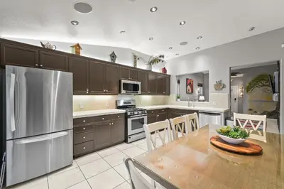 a kitchen with a table and a stainless steel refrigerator at Casita Andrade in Turlock