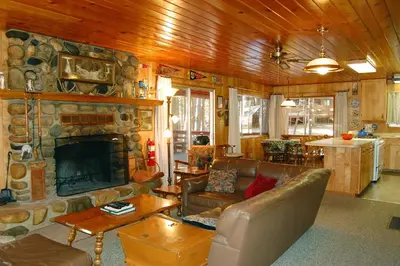 a living room with a stone fireplace and leather furniture at Cozy 2Br Retreat with Scenic Deck & Outdoor Dining in Wawona
