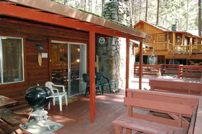 a log cabin with a bench and a porch at Cozy 2Br Retreat with Scenic Deck & Outdoor Dining in Wawona