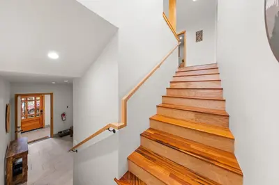 a staircase in a home with white walls and wooden floors at Remodeled 4BDR Cabin with AC Lake Views Hot-Tub Bunk Room Excellent Location in Kings Beach