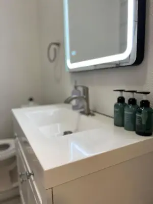 a bathroom with a sink and a mirror at Cozy Tower Hideaway in Fresno