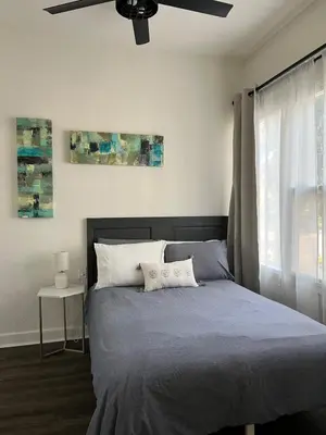 a bedroom with a bed with a ceiling fan at Cozy Tower Hideaway in Fresno