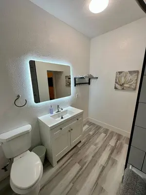 a bathroom with a white toilet and a sink at Cozy Tower Hideaway in Fresno
