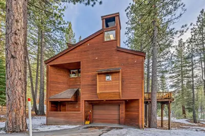 a wooden house in the middle of a forest at Cozy Truckee Vacation Rental with Fireplace & Deck in Truckee