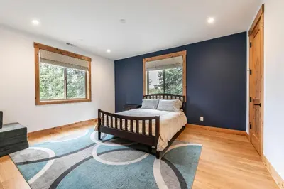 a bedroom with a bed and a blue wall at Radiant Retreat by Tahoe Getaways - 4 BR in Tahoe Donner with Hot Tub & HOA in Truckee