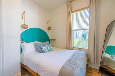 a bedroom with a large bed with a green headboard at Charming Family 2BR Midtown Reno - Pets Welcome in Reno