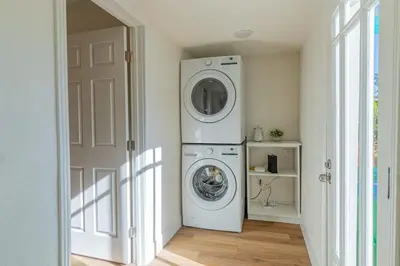 a laundry room with a washer and dryer next to a door at Charming Family 2BR Midtown Reno - Pets Welcome in Reno