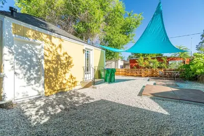 a patio of a house with a blue umbrella at Charming Family 2BR Midtown Reno - Pets Welcome in Reno