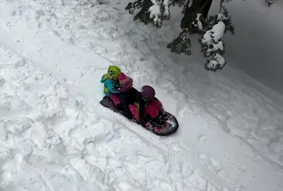 a person on a snowboard in the snow at Bear Haus - Sledding At Cabin - Forest Views - Foosball in South Lake Tahoe