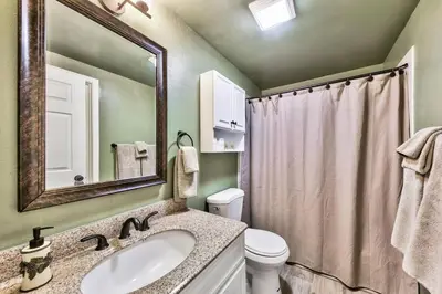 a bathroom with a sink and a toilet and a mirror at Bear Chalet - Snow Play - 4 Bedrooms - Foosball in South Lake Tahoe