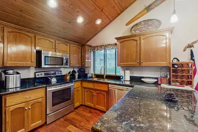 a kitchen with wooden cabinets and a counter top at Bearfoot Getaway in Shaver Lake