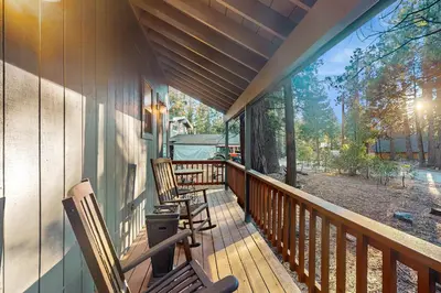a porch with two rocking chairs on a house at Bearfoot Getaway in Shaver Lake