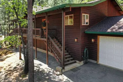a small house with a deck and a garage at Great Cabin with AC Firepit Fireplace in Arnold