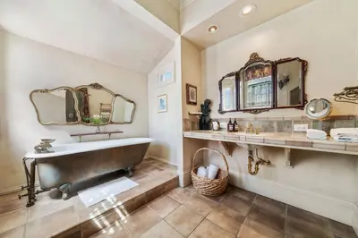 a bathroom with a large tub and a mirror at Brinnwood Bed & Breakfast in Sutter Creek