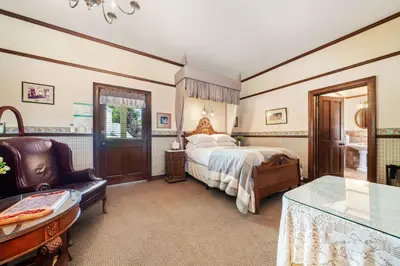 a bedroom with a bed and a chair at Brinnwood Bed & Breakfast in Sutter Creek