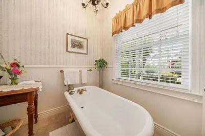 a white bath tub in a bathroom with a window at Brinnwood Bed & Breakfast in Sutter Creek