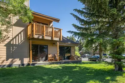 a house with a balcony and a yard at Scenic Views Hot Tub Ski Shuttle Pet Friendly in Mammoth Lakes