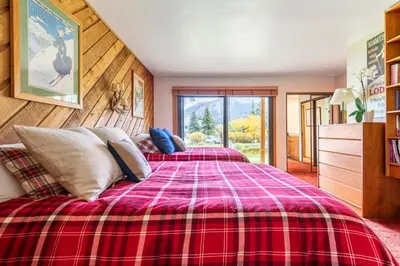 a bedroom with two beds with a red plaid blanket at Scenic Views Hot Tub Ski Shuttle Pet Friendly in Mammoth Lakes