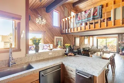 a kitchen with a counter top and a living room at Scenic Views Hot Tub Ski Shuttle Pet Friendly in Mammoth Lakes