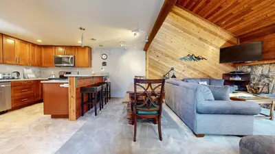 a living room with a couch and a kitchen at Mammoth Sierra Townhomes #38 condo in Mammoth Lakes