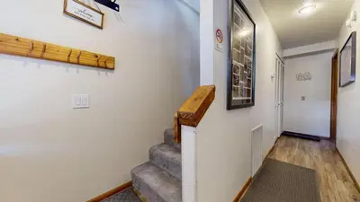 a hallway with a staircase and a stair case at Mammoth Sierra Townhomes #38 condo in Mammoth Lakes