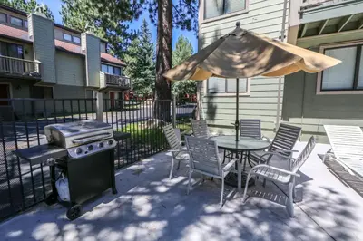 a patio with a table and a grill and chairs at Mammoth Sierra Townhomes #38 condo in Mammoth Lakes