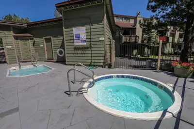 a jacuzzi tub in a yard next to a house at Mammoth Sierra Townhomes #38 condo in Mammoth Lakes