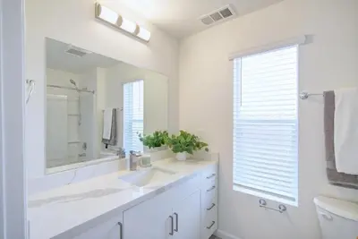a white bathroom with a sink and a mirror at Orchard Parks in Tracy