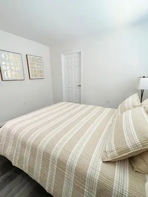 a bedroom with a bed with a striped comforter at Orchard Parks in Tracy