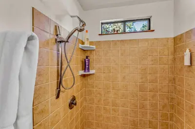 a bathroom with a shower with a window and a sink at Cozy Carnelian Bay Escape with Deck and Foosball in Carnelian Bay
