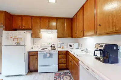 a kitchen with white appliances and wooden cabinets at Sierra Park Villas 40 H in Mammoth Lakes