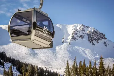 a ski lift with a snow covered mountain in the background at Sierra Park Villas 40 H in Mammoth Lakes