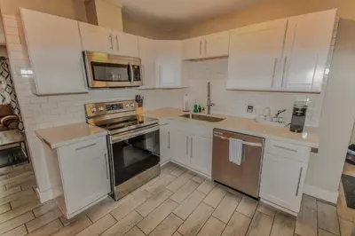 a kitchen with white cabinets and stainless steel appliances at Reno Retreat 3 King Beds by Casinos and University in Reno