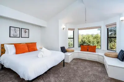 two beds in a white room with windows at Spacious Mountain View Oasis - Pool, Spa & Game Rm in Oakhurst